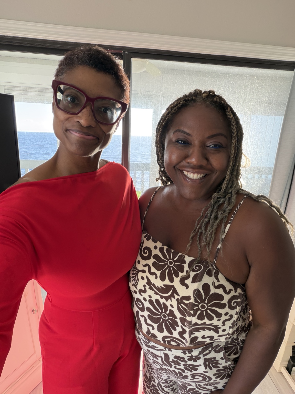 Dr. Sherry-Ann Brown and Rikkia smiling together beside the waterfront home